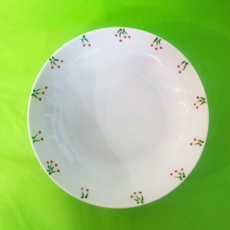 Vue dessus assiette creuse en porcelaine blanche peinte à la main, décor cerises