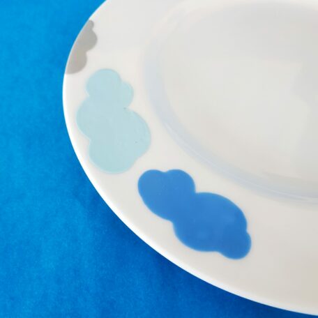 Détail assiette à dessert à bords en porcelaine blanche peinte à la main, décor nuages 